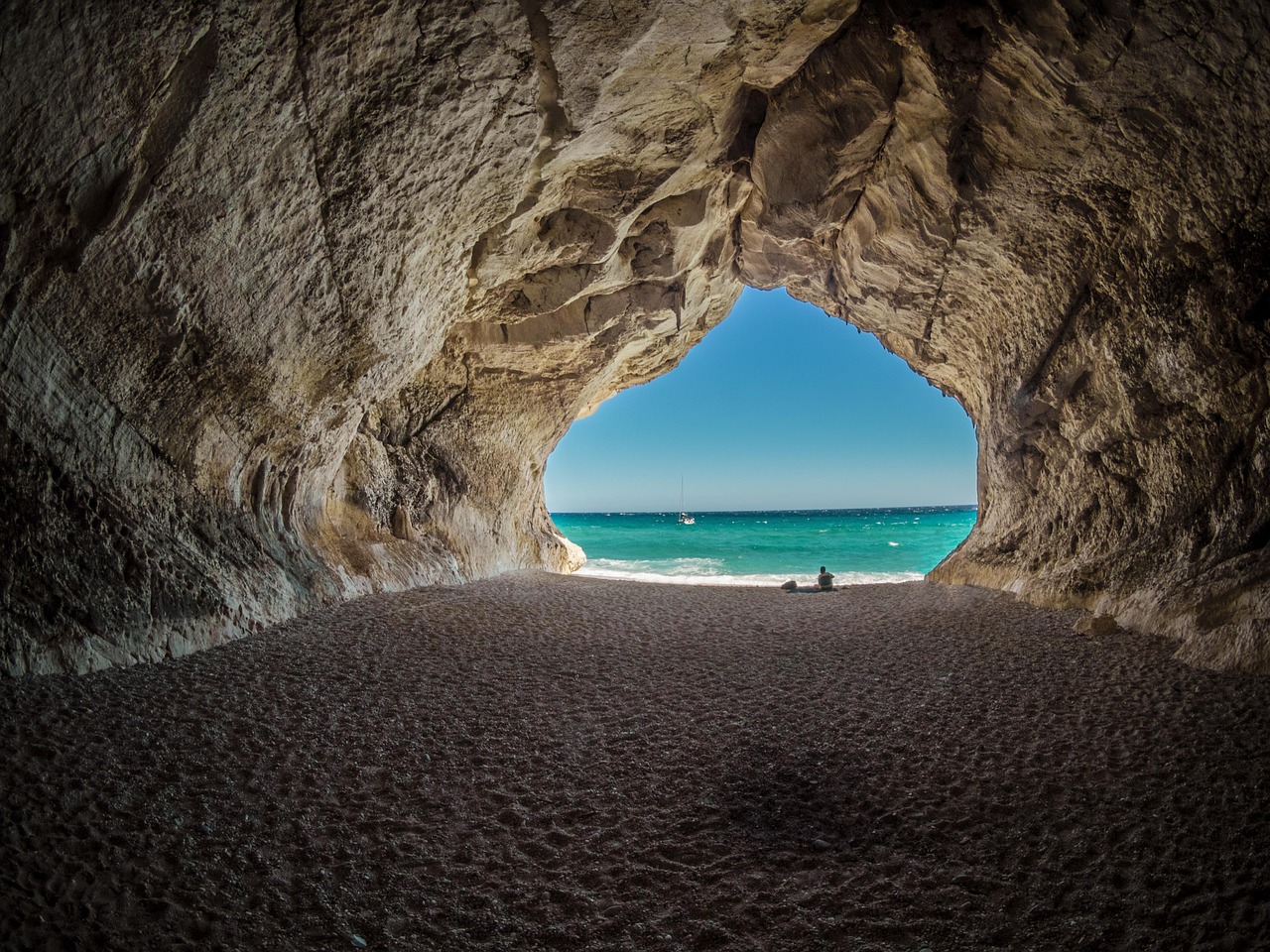 Blick aus einer Felshöhle auf das türkise Meer am Golfo di Orosei